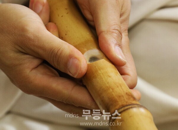 대금에 입김을 넣어 소리를 내는 부분과 첫째 음공 중간의 청공에 갈대 속에서 채취한 얇은 막을 붙치고 있는 권봉현 명인 (사진 임무택기자)