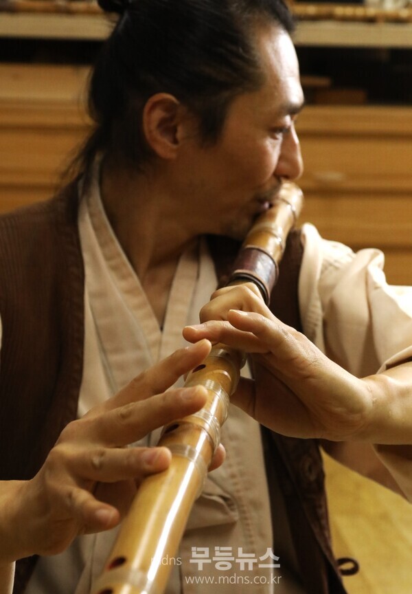 완성된 대금을 연주해보고 있는 권봉현 명인 (사진 임무택기자)