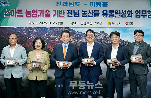 김영록 전라남도지사가 25일 오후 도청 접견실에서 열린 한화 아워홈 김태원 대표이사와 '스마트 재배관리 솔루션'을 적용한 농산물의 안정적 생산과 유통활성화를 위한 업무협약식에서 아워홈에서 제작한 전남산 해남김치를 들어보이고 있다.(전남도 제공)