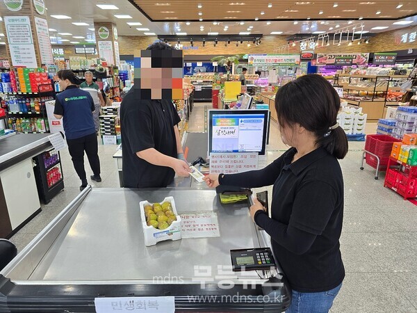 암태면 주민이 민생회복 소비쿠폰으로 지급된 지역사랑 상품권으로 하나로마트에서 과일을 구매하고 있다./신안군 제공