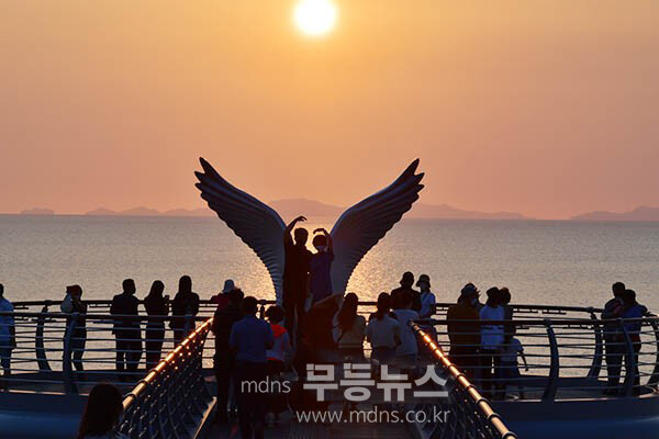 황홀한 노을과 함 께 괭이갈매기 조형물에서 기념촬영 (조경륜 / 자료사진)