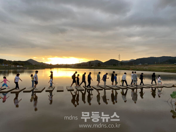 축제장 1주차장에서 주무대로 향하는 양방향 징검다리를 시민과 관광객들이 통행하고 있다.