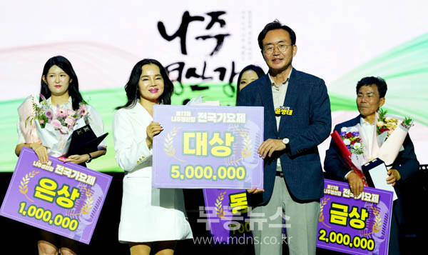 윤병태 시장(오른쪽)이 ‘제17회 나주 영산강 전국 가요제’에서 대상을 수상한 장성희 씨에게 상금 500만 원을 전달하고 기념사진을 찍고 있다. (사진 제공-나주시)