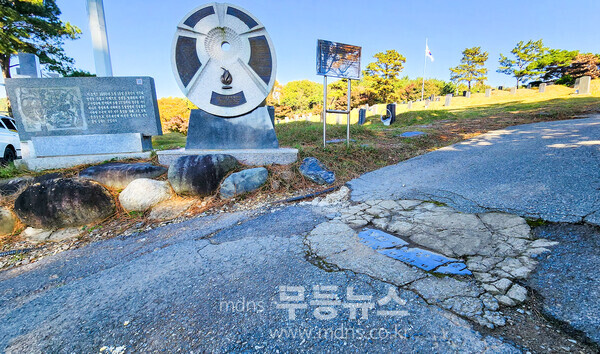 망월동 5·18 유공자 및 민족민주열사묘역 입구에는 대리석으로 된 표지석 하나가 땅바닥에 처박혀 있다. 그리고 오늘도 묘역을 찾는 참배객들의 발에 짓밟혀 훼손되어 없어질 위기에 있다.