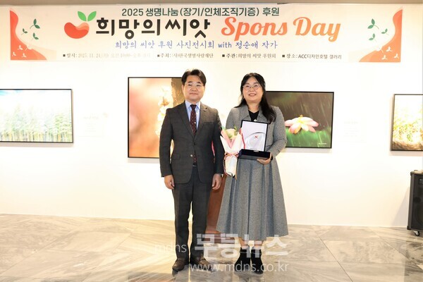 김동화 한국생명사랑재단 이사장이 정순애 작가에게 감사패를 전달하고 기념촬영을 하고 있다.